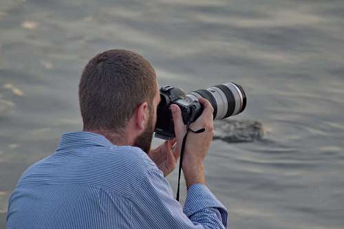report photojournalist device beach lens photographer professional instrument nature water