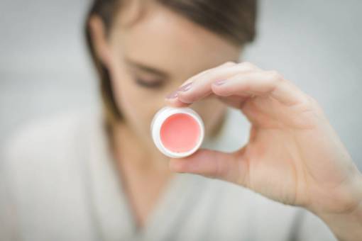 sostener mujer sosteniendo bálsamo labial rosa moda lápiz labial hembra
