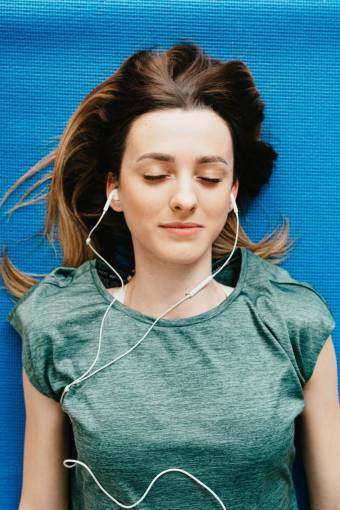 technology Young woman lying down listening to music with headphones