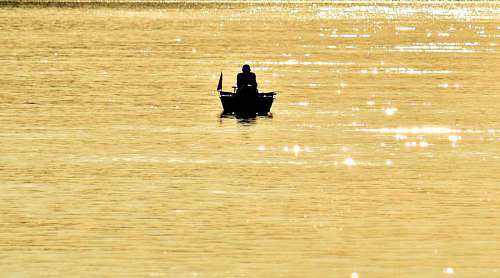 distance boat fisherman fishing beach glow distance shadow golden paddle silhouette water
