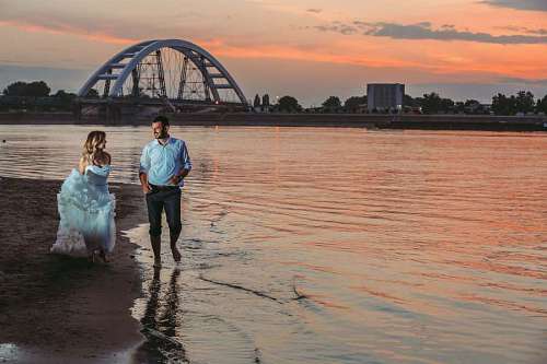 wife wife beach walking sunset married husband pier bridge river water 