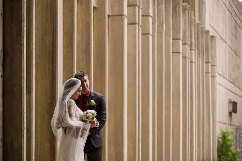 wife posing bride husband wife street groom architecture wall