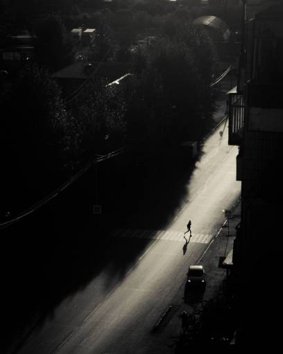 A person crossing an avenue in the city