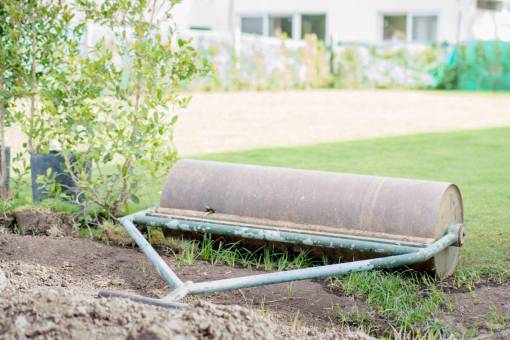 cuidado Rodillo manual de hierro para césped. Aplanar una superficie de césped de jardines