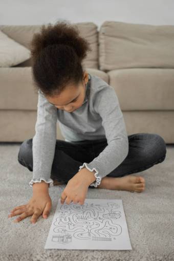 girl A girl solving a maze drawn on a paper