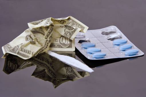 conceptos Adicción a las drogas, líneas de cocaína en polvo, pastillas y billete de un dólar