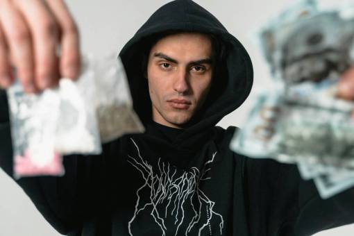 conceptos Tráfico de drogas, hombre sosteniendo una bolsa de cocaína y billetes de un dólar