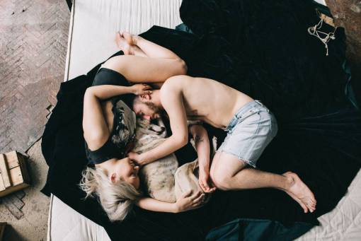 dog Couple sleeping with their dog in bed