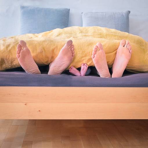 intimate Feet of a family while sleeping in their bed