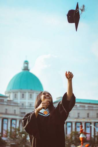 emociones Mujer graduada arrojando su sombrero