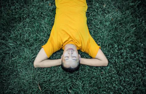 tranquil-scene Man lying in a park sleeping on the grass