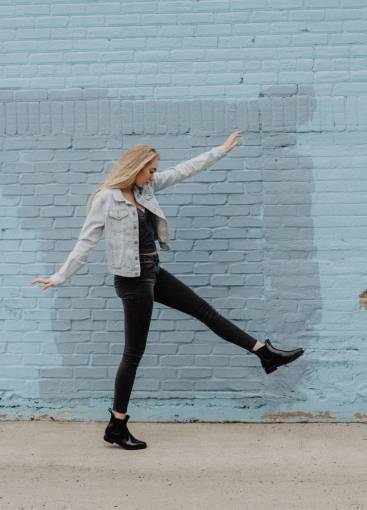 casual-clothing Woman dancing in front of a brick wall