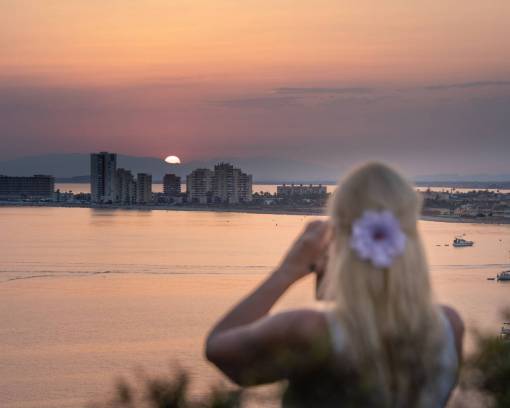 sunset Woman on vacation taking a photo at sunset in front of the sea