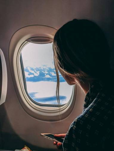 cielos Mujer viajando en avión y mirando por la ventana