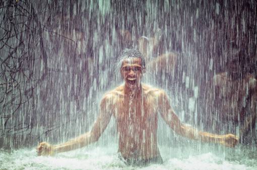 smiling Young man screaming with happiness in the rain