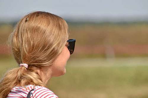 blonde smiling nature pretty hairstyle sunglasses outdoors grass enjoyment hamburger sandwich eating side woman