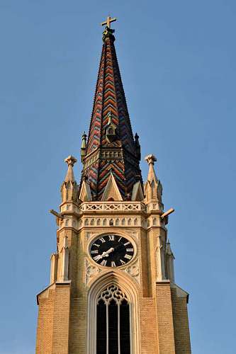 medium-shot church tower cross roof clock bricks building architecture landmark medium