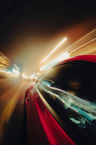 noche Automóvil viajando a alta velocidad por la noche en la ciudad