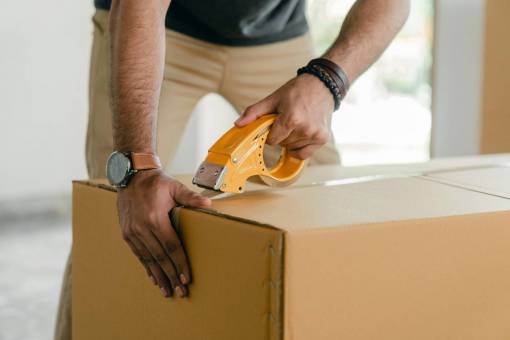 one-man-only Man closing a cardboard box with adhesive tape