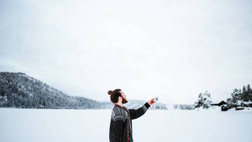 invierno Hombre arroja una taza de agua hirviendo que se convierte en vapor debido al frío