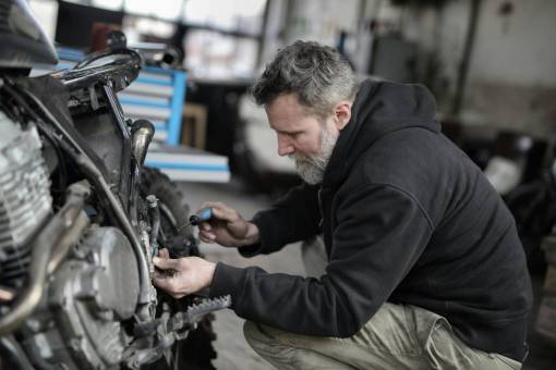 man Mechanic repairing a motorcycle engine in his workshop