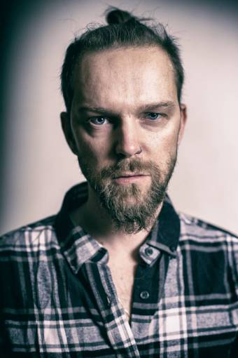 fashion Portrait of a young man looking at camera with a beard
