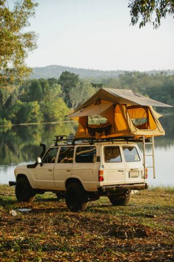 landscape Van with tent on the roof in front of a lake