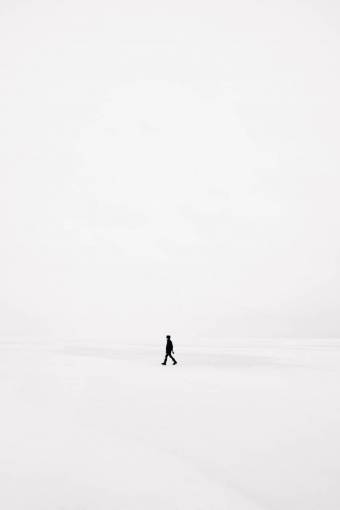 invierno Un hombre caminando solo en la nieve.