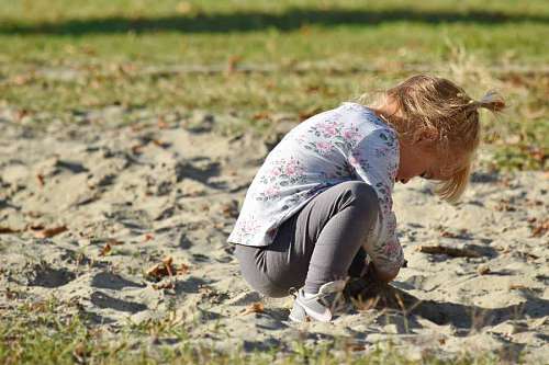 blonde playful enjoyment child pretty grass sand outdoors nature 