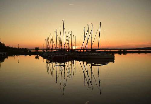 sailboat sailboat reflection silhouette bay yachts yacht marina sunset water