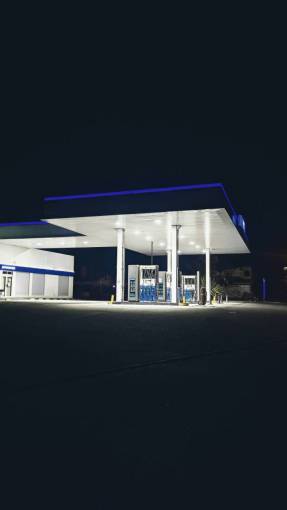 car Gas Station Illuminated at Night with Bright Lights
