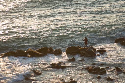 Man fishing at coast rocks 
