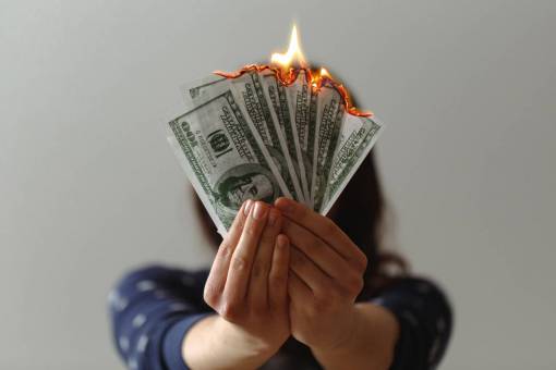 conceptos Mujer quemando billetes de 100 dólares