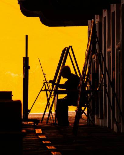 landscape Painter facing the sea painting a picture at sunset