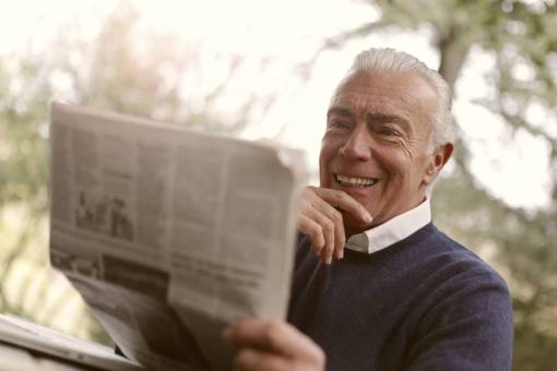 park Senior man reading newspaper in the park