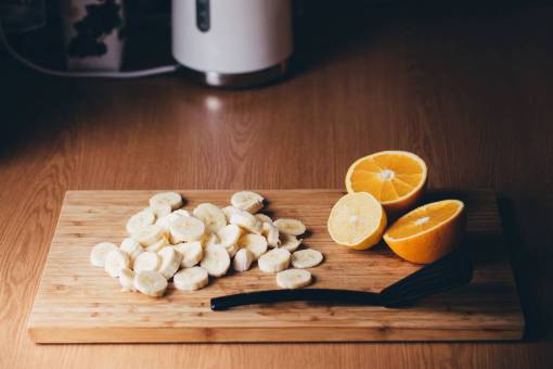 cortar plátanos naranjas frutas comida sana tabla de cortar cocina