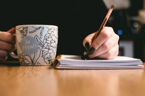 escritorio ser feliz taza de café mujer sosteniendo bolígrafo bloc de notas