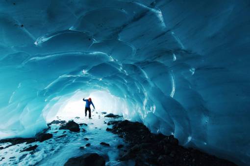 bosques Patinando en una pequeña cueva de hielo debajo del glaciar Byron, en el Bosque Nacional Chugach de Alaska