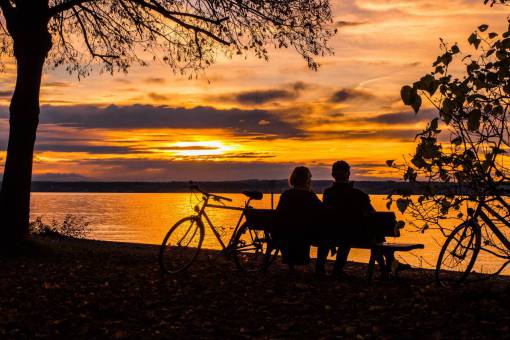 silhouette outdoors men women couple;sunset;lake;bicycle;bench nature sunset sun