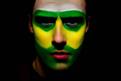 brazo fútbol;ventilador;brasil;pintado;cara raza caucásica fondo negro hombres adultos una persona rostro humano