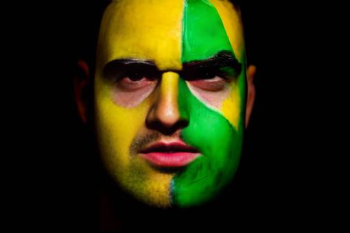 brazo fútbol;aficionado;brasil;pintado;rostro una persona fondo negro rostro humano deporte pintura facial hombres