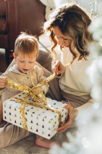 contenido Niño con su madre abriendo regalos de Navidad