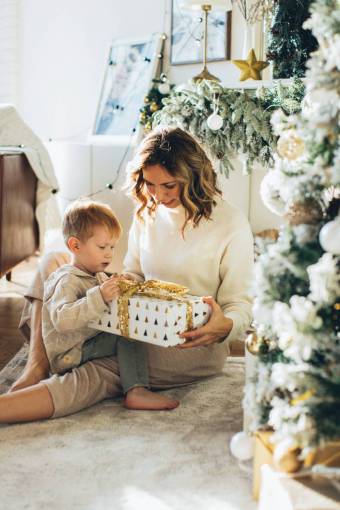 contenido Niño con su madre abriendo regalos de Navidad
