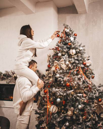 wife Couple decorating Christmas Tree at home