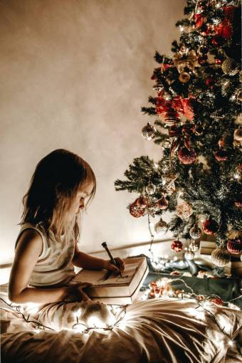 conceptos y temas niña dibujando frente al árbol de navidad