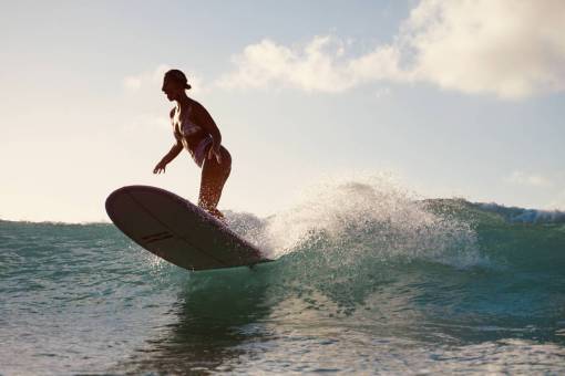 Woman surfing at sunset