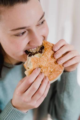 tenencia Mujer comiendo hamburguesa