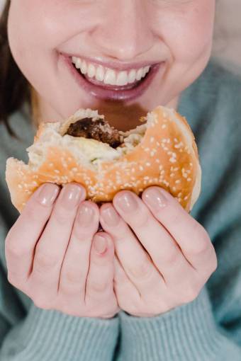 tenencia Mujer comiendo hamburguesa