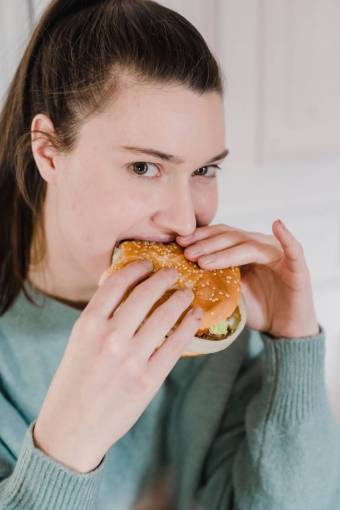 tenencia Mujer comiendo hamburguesa