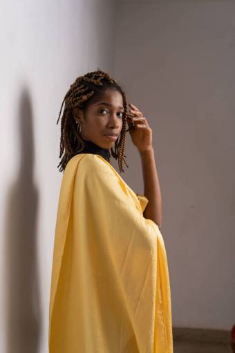 moderno Mujer en traje amarillo mirando a la cámara